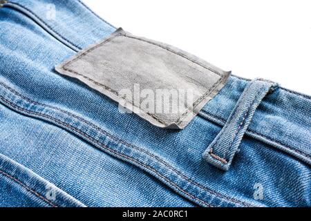 In der Nähe von Leer Leder kleidung Aufkleber auf blaue Jeans mit Gürtelschlaufe. Auf der Oberseite für Kopie Raum isoliert. Stockfoto