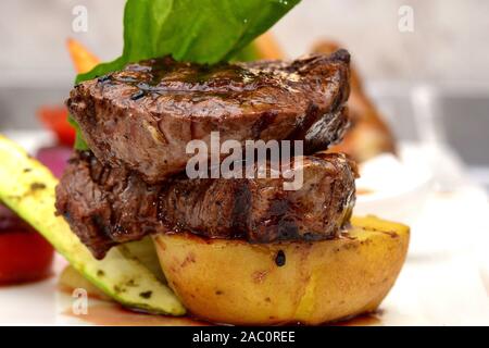 Küchenchef Bonfile Steak braten Kartoffel mit Salat, gerösteten Gemüsegarnitur und brocolli Brei Stockfoto