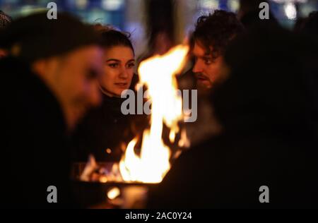 Berlin, Deutschland. 29 Nov, 2019. Besucher sprechen durch Herd Feuer auf dem Weihnachtsmarkt auf dem Alexanderplatz in Berlin, Deutschland, an November 29, 2019. Credit: Shan Yuqi/Xinhua/Alamy leben Nachrichten Stockfoto