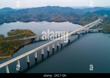 Peking, China. 26 Nov, 2019. Luftaufnahme auf November 26, 2019 zeigt einen Zug, der auf einer Brücke über den Danjiangkou Behälter während eines Versuches der Wuhan-Shiyan high-speed Railway in der zentralen Provinz Hubei China übernommen. Die Wuhan-Shiyan high-speed Railway wurde in Betrieb am 07.11.29. Credit: Xiong Qi/Xinhua/Alamy leben Nachrichten Stockfoto