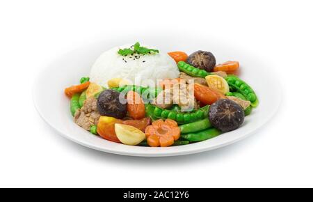 Rühren Sie gebraten Zuckerschoten mit Schweinefleisch und geschnitzten Karotten Blume und Mais shap und Knoblauch serviert mit Reis ontop Sesam und Blatt Minze (thua Lantao Phat Moo) EIN Stockfoto