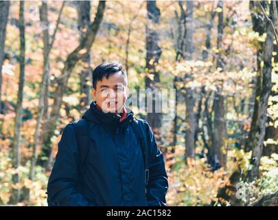 Asiatischer Mann genießen Herbst Wald in Oirase Schlucht, Aomori, Japan. Stockfoto