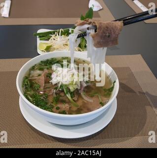 Traditionelle vietnamesische Nudelsuppe (Pho Bo) in einem lokalen Restaurant. Pho war auf Welt 50 Die Leckersten Lebensmittel durch CNN Gehen zusammengefasst aufgeführt. Stockfoto