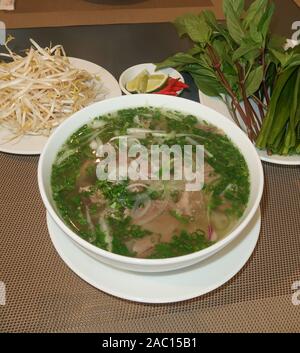 Traditionelle vietnamesische Nudelsuppe (Pho Bo) in einem lokalen Restaurant. Pho war auf Welt 50 Die Leckersten Lebensmittel durch CNN Gehen zusammengefasst aufgeführt. Stockfoto