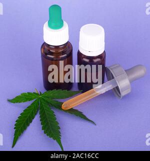 Die medizinische Verwendung von Cannabis, Flaschen mit Tinktur von Marihuana Öl auf blauem Hintergrund. Stockfoto