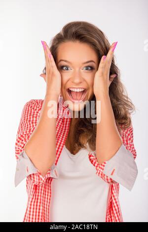 Erstaunt niedliche Mädchen öffnen den Mund halten sich an den Händen in der Nähe von Kopf Stockfoto