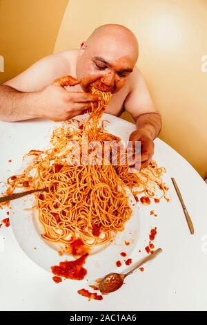 Foto von einem übergewichtigen glatzköpfige Mann einen Teller Spaghetti. Shot mit Fish-eye Objektiv. Stockfoto