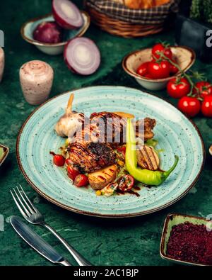 Gegrillte Hähnchenschenkel serviert mit gegrilltem Gemüse und frischem Pfeffer Stockfoto