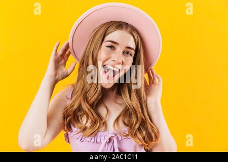 Bild einer jungen fröhlichen Happy girl über gelb Wand Hintergrund tragen Hut isoliert. Stockfoto