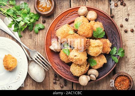 Champignons paniert. Panierte Champignons in vintage Holz- Hintergrund Stockfoto