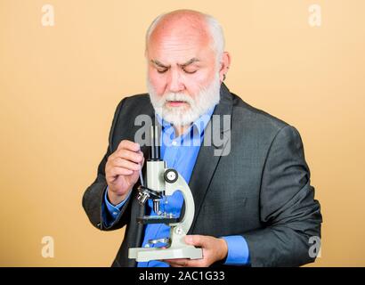 Promotion und Habilitation die Beschäftigung. Biologie erfahrene Dozentin. Molekularbiologie PhD Projekte. Reifer mann Anzug mit Mikroskop. Professor Dozent. Wissenschaftler der Mikrobiologie. Stockfoto