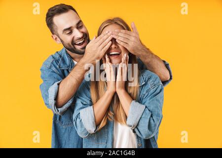 Porträt eines attraktiven fröhlichen jungen Paar legere Kleidung, die auf gelben Hintergrund isoliert Stockfoto