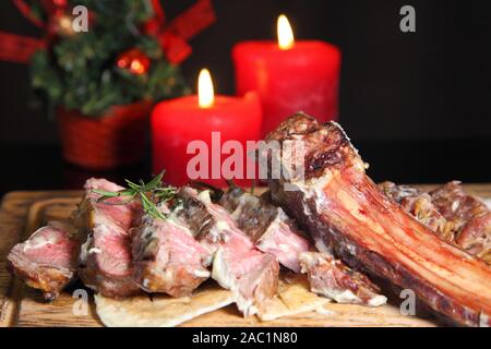 Rib Eye Steak auf dem Tisch des Neuen Jahres. Rib Eye Steak braten auf einem Holzbrett mit Soße und Salz. Rindersteak auf Holzplatte. Stockfoto