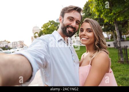 Bild eines fröhlichen positive erstaunlich jungen Liebenden Paar durch die Straße draußen, ein selfie durch die Kamera. Stockfoto