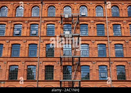 Klassische industrielle Gebäude aus rotem Backstein Fassade mit mehreren Windows Hintergrund. Stockfoto