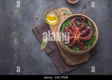 Gekochte Krake mit Kräutern und Gewürzen in Holzplatte, kopieren Sie Spase Stockfoto