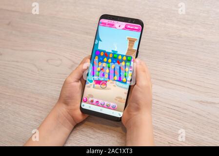 Sarajevo, Bosnien und Herzegowina - 30. November 2019: Candy Crush Saga puzzle video Spiel auf moderne smart phone in Kid Hände close-up Stockfoto