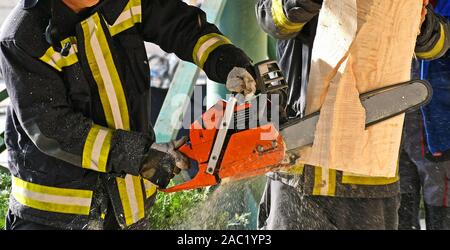 Feuerwehrmann arbeitet mit einer Kettensäge outdoor Stockfoto