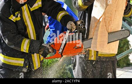 Feuerwehrmann arbeitet mit einer Kettensäge outdoor Stockfoto