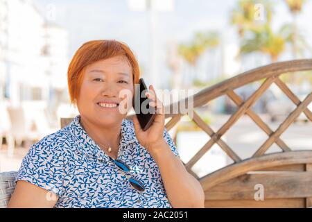 Asiatische Frau am Telefon sprechen Stockfoto