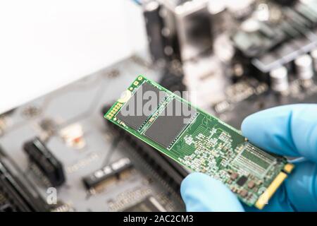 In der Nähe der Installation von SSD-Festplatte auf der Hauptplatine. Motherboard im Hintergrund. Stockfoto