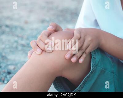 Kind Junge fühlen Knieschmerzen nach Spielen. gesund problem Konzept. Stockfoto