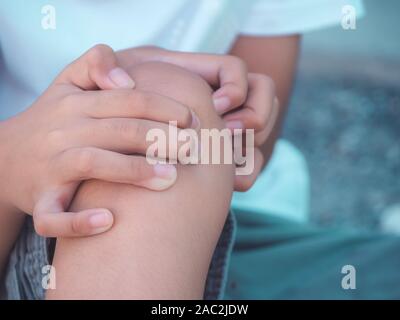 Kind Junge fühlen Knieschmerzen nach Spielen. gesund problem Konzept. Stockfoto