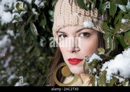 Porträt einer Frau im Schnee mit Pelzmantel und Strickmütze. Selektiver Fokus Stockfoto