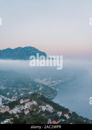 Ansicht von oben von Minori Strand auf Foggy Mountain Village in Ravello Amalfi Küste, Italien Stockfoto