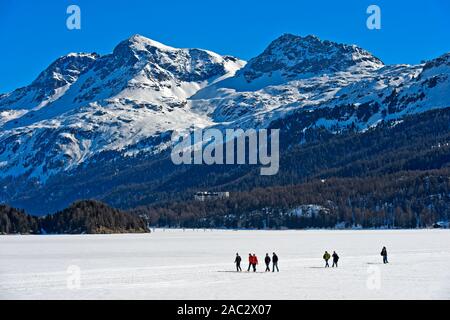 Fußgänger die gefrorenen See Sils, Silsersee, Corvatsch Massiv hinter der Kreuzung, Sils im Engadin, Graubünden, Schweiz Stockfoto