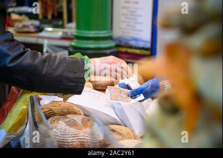LONDON - September 27, 2019: Ein Kunde gerade für Laibe Brot zu einem Brot bezahlt in Borough Market, London. Stockfoto