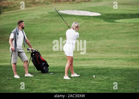 Versuchen, den Ball zu treffen. Paar Golf Spieler haben gute Spiel in ihrem Wochenende Zeit Stockfoto