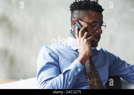 Nahaufnahme Foto von attraktiven eleganter schwarzer Geschäftsmann in Anzug sprechen Telefon in Deal Stockfoto