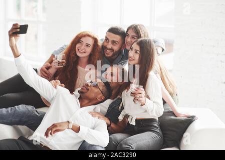 Ein wenig Alkohol wird nicht überflüssig werden. Gruppe der multirassischen Mannschaftskameraden Haben der guten Zeit auf Ihre Pause und einige Fotos Stockfoto