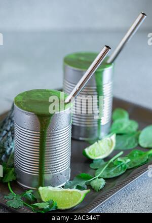 Gesund Grünkohl und Spinat Smoothies serviert in der Umfunktionierten Dosen aus Metall mit Edelstahl Trinkhalme Stockfoto