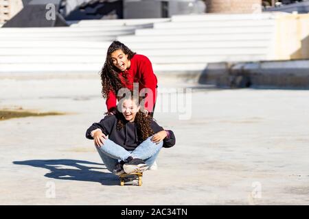 Zwei schöne Teens spielen mit Skateboard am sakte Park Stockfoto