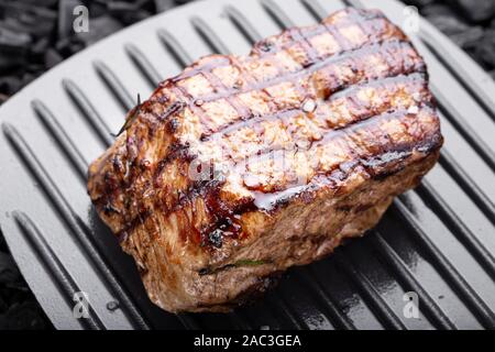 Holzkohle gegrilltes Steak auf einem schwarzen Hintergrund. Grill Streifen auf Steak sichtbar Stockfoto