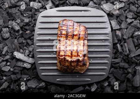 Holzkohle gegrilltes Steak auf einem schwarzen Hintergrund. Grill Streifen auf Steak sichtbar Stockfoto