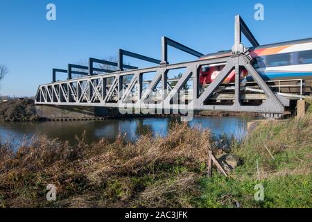 Zug durch Eiserne Brücke läuft Stockfoto