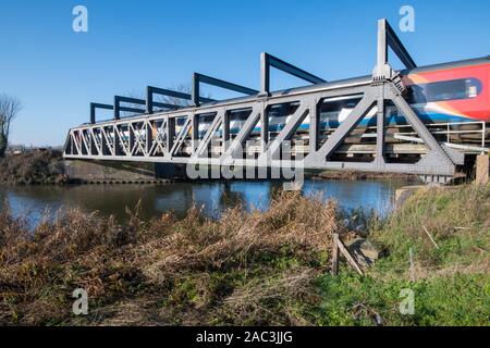 Zug durch Eiserne Brücke läuft Stockfoto