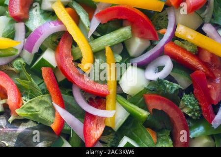 Extreme Nahaufnahme eines gesunden rohen Salat platzen mit bunten Ernährung und Gemüse, einschließlich Spring Mix Grüns, Spinat, Gurken, Tomaten, re Stockfoto