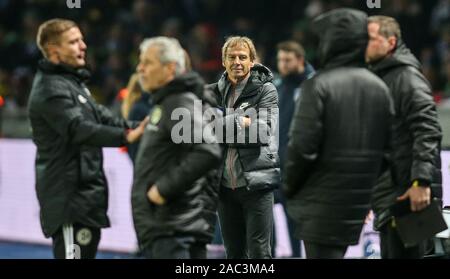 Berlin, Deutschland. 30 Nov, 2019. Fussball: Bundesliga, Hertha BSC - Borussia Dortmund, 13. Spieltag, Olympic Stadium. Berlins Trainer Jürgen Klinsmann steht lächelnd auf dem Spielfeld mit verschränkten Armen. Credit: Andreas Gora/dpa - WICHTIGER HINWEIS: In Übereinstimmung mit den Anforderungen der DFL Deutsche Fußball Liga oder der DFB Deutscher Fußball-Bund ist es untersagt, zu verwenden oder verwendet Fotos im Stadion und/oder das Spiel in Form von Bildern und/oder Videos - wie Foto Sequenzen getroffen haben./dpa/Alamy leben Nachrichten Stockfoto