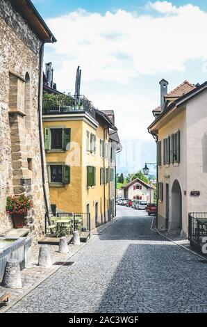 St. Saphorin, Schweiz - 9. Juli 2019: Historische Straße im malerischen Dorf St. Saphorin Weinbereitung in Schweizer Weinregion Lavaux. Traditionellen Häusern, gepflasterten Gassen. Stockfoto