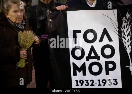 Moskau, Russland. 30. November 2019 Personen Banner mit Aufschrift im Russischen "Holodomor" während der Aktion in Erinnerung an die Opfer der großen Hungersnot am Solovetsky Stein in der Mitte der Stadt Moskau, Russland. Der Holodomor war eine künstlich angelegte Hungersnot durch die sowjetischen Behörden provoziert, die von Diktator Josef Stalin geführt. Das Ergebnis war der Tod von mehr als sieben Millionen sowjetischen Menschen. Stockfoto