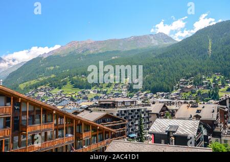 Schöne Stadtbild von Alpine Village Zermatt in der Schweiz während der Sommersaison. Die Schweizer Alpen sind beliebtes Urlaubsziel. Holz- Chalets im Tal von Bergen und Wäldern umgeben. Stockfoto