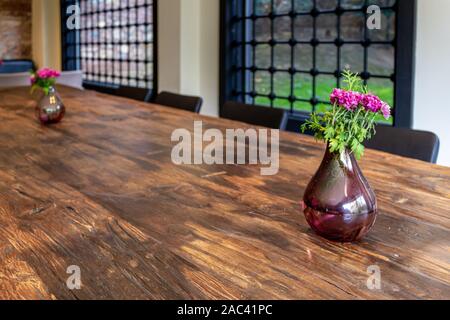 Vase und Strauß Blumen auf braun Holz Tisch. Home Dekoration Design. Bügeleisen gesperrt home Glas Fenster im Hintergrund Stockfoto