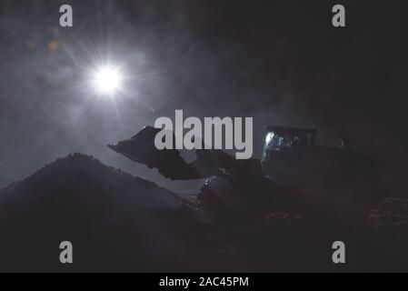 Traktor arbeitet auf der Baustelle bei Nacht Konzept. Stockfoto