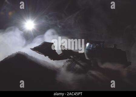 Traktor arbeitet auf der Baustelle bei Nacht Konzept. Stockfoto