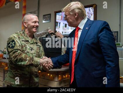 Us-Präsident Donald Trump schüttelt Hände mit Army Command Sgt. Maj. John W. Troxell, Senior Berater der Vorsitzende des Generalstabs, während eine überraschung Thanksgiving Tag Besuch in Bagram, Afghanistan zu Bagram Air Field November 28, 2019. Das Trump Besuch war sein erster nach Afghanistan, seit Präsident zu werden. Stockfoto