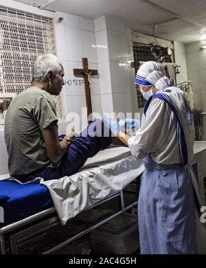 Mutter Teresa Schwester, die einen Patienten zu Hause wegen des Sterbens in Kolkata, Indien, behandelt Stockfoto